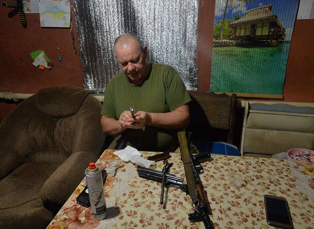 Un soldato pulisce la sua arma vicino Horlivka, Donetsk - Febbraio 3, 2022. REUTERS/Oleksandr Klymenko